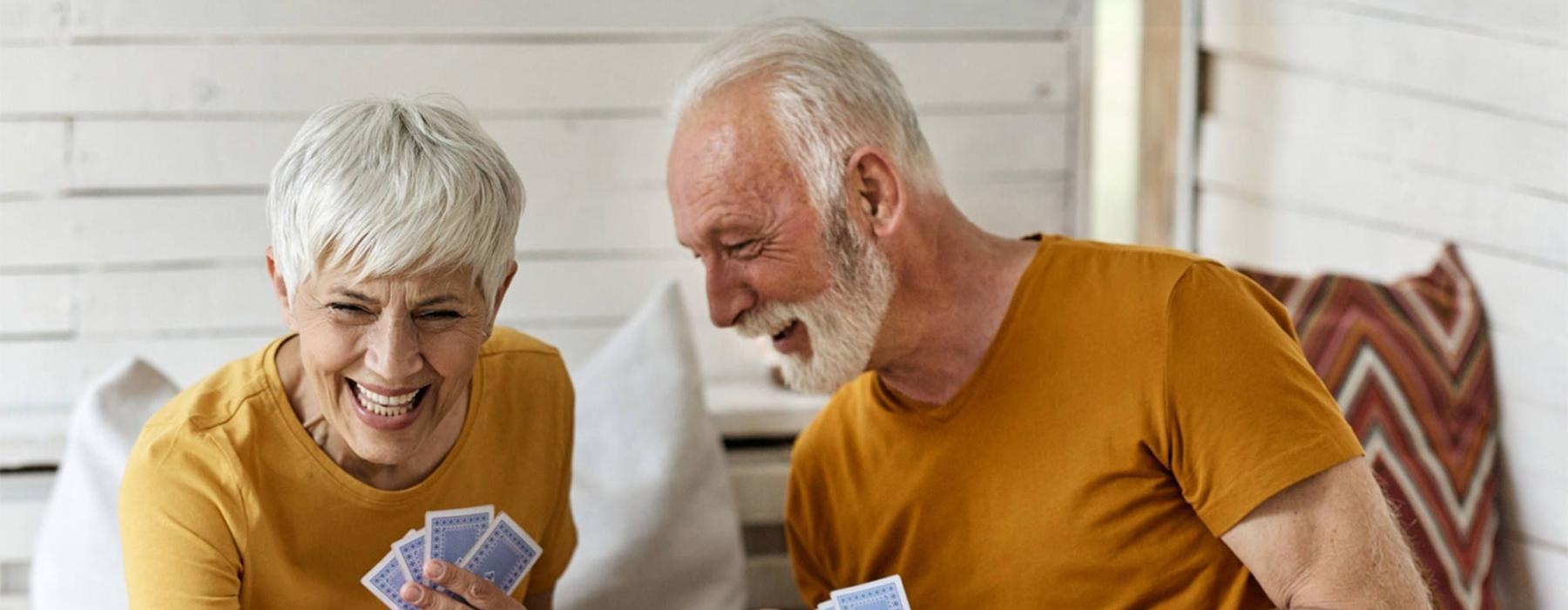 a man and woman sitting at a table playing cards