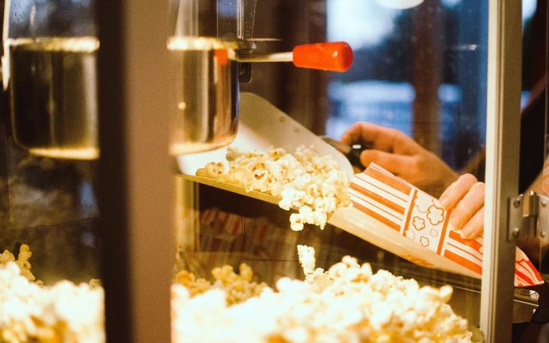 a person pouring popcorn into a container