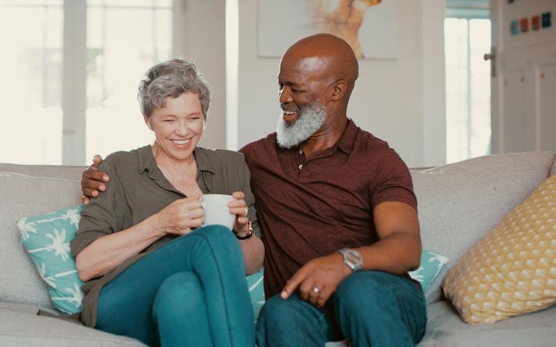 smiling, older couple, sit together on a couch